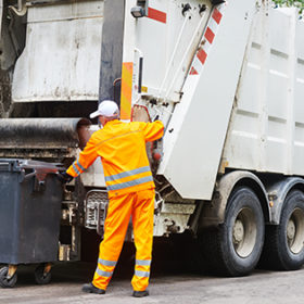Worker of urban municipal recycling garbage collector truck loading waste and trash bin