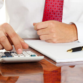 businessman with a calculator. calculation of costs, revenue, balance sheet