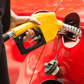 Close-up Of Businesswoman's Hand Refueling Car's Tank By Holding Petrol Pump Nozzle
