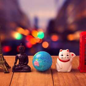 Travel around the world concept. Souvenirs from around the world on wooden table over city bokeh background