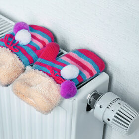 Heating radiator with knitted mittens indoors