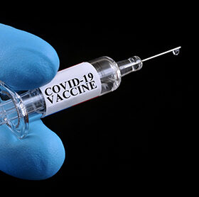 Concept of covid-19 vaccine with syringe on noir background