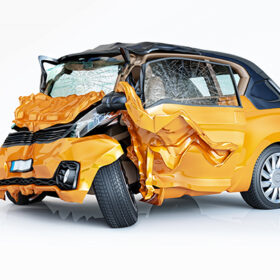 Single car crashed. Yellow city car havily damaged on the front part. Isolated on white background. Perspective view.