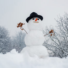 New year Christmas concept. Snowman outdoor. Happy smiling snow man on sunny winter day. Cute little snowman outdoor. Winter background with snowflakes and snowman.