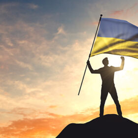 Ukraine flag being waved by a man celebrating success at the top of a mountain. 3D Rendering