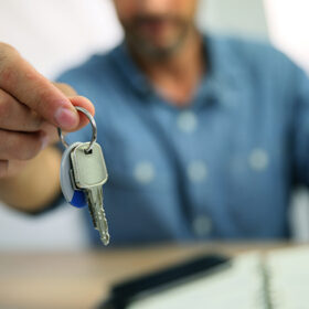 Real estate agent giving keys to property owner