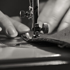 Sewing Process - Women's hands behind her sewing. Monochrome.