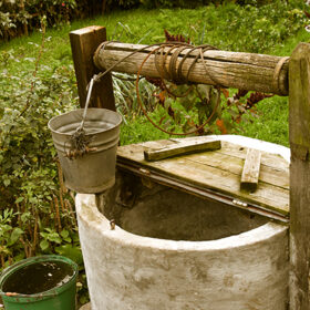 old rotten water well in sumer garden, rural scenery