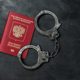 Russian passport with handcuffs on black background