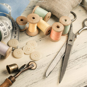 Set of reel of thread, scissors, buttons, fabric and pins for sewing and needlework in Shabby Chic style. For this photo applied toning in retro style.