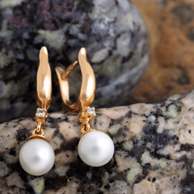 Pair of Beautiful Gold Earrings with Diamonds and Pearls on the natural stones background