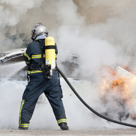 a firefighter putting out a car that was burning