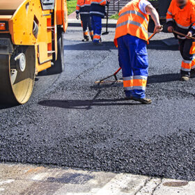 Roller and workers on asphalting and repair of city streets
