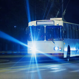 trolleybus goes on city street at night