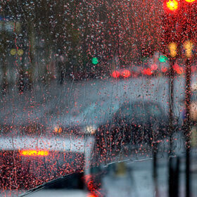 London rain view to red bus through rain-specked window