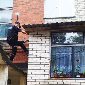 поліцейский лізе через балкон в квартиру
